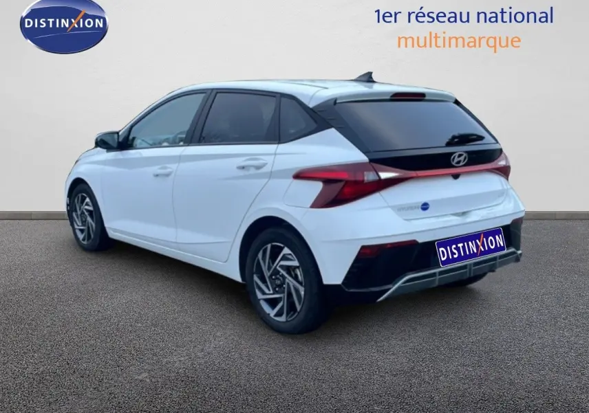 Vue 3/4 arrière droite d'une Hyundai i20 blanche Atlas avec feux arrière LED et jantes alliage distinctives.