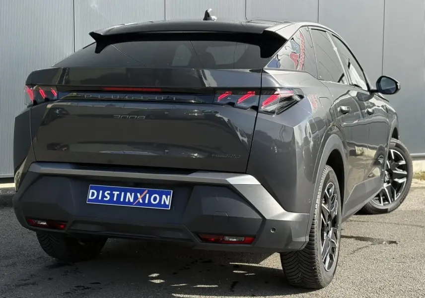 Vue 3/4 arrière droite du Peugeot 3008 Hybrid gris Titane avec jantes noires et feux arrière à griffes LED.