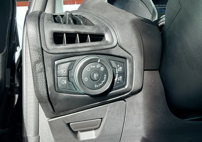 Vue rapprochée de l’intérieur noir de la Ford Focus 1.5 TDCI 120 ST Line, avec accoudoir central ouvert et surpiqûres rouges.