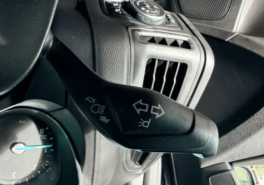 Vue intérieure côté conducteur de la Ford Focus 1.5 TDCI 120 ST Line 2018 avec sièges tissu noir et surpiqûres rouges.