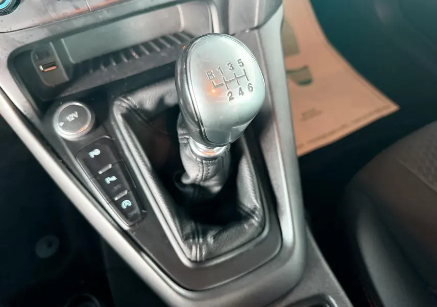 Vue rapprochée du volant noir en cuir de la Ford Focus 1.5 TDCI 120 ST Line, avec tableau de bord et écran tactile visibles.