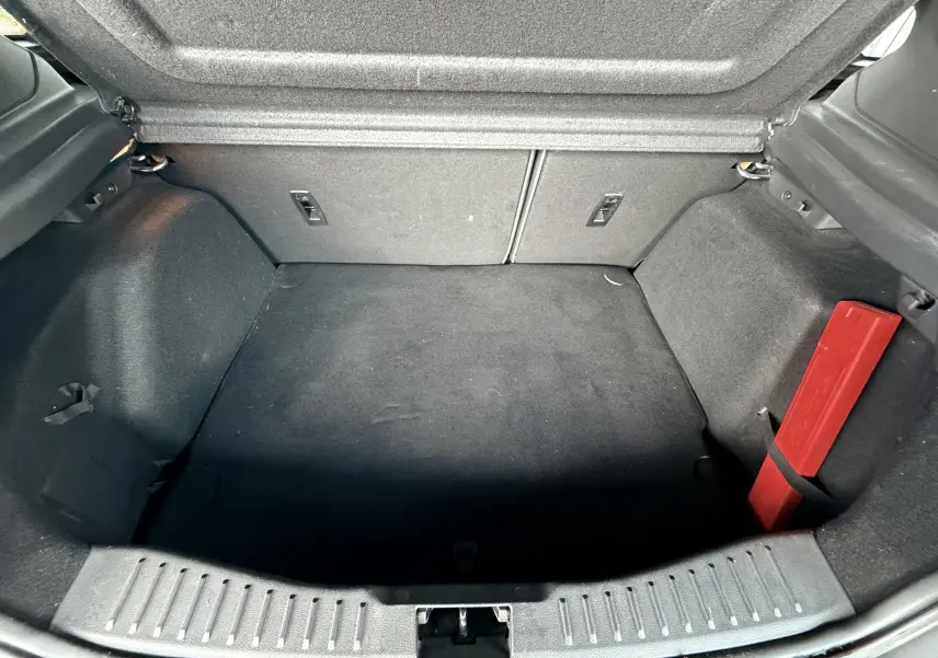 Gros plan sur les commandes audio au volant en cuir perforé noir d'une Ford Focus 1.5 TDCI 120 ST Line grise de 2018.