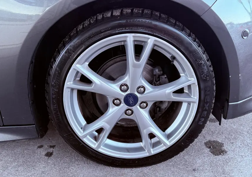 Gros plan sur la jante alliage argentée et pneu Nexen du côté avant gauche d'une Ford Focus grise 2018.