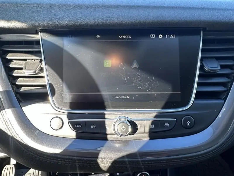 Écran tactile central de l’Opel Grandland X blanc 2018, vue rapprochée du tableau de bord avec commandes audio et navigation.