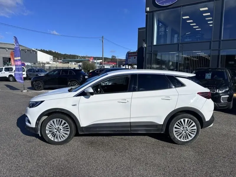 Vue de profil côté gauche d’un Opel Grandland X blanc 2018 avec jantes alliage et protections noires basses.