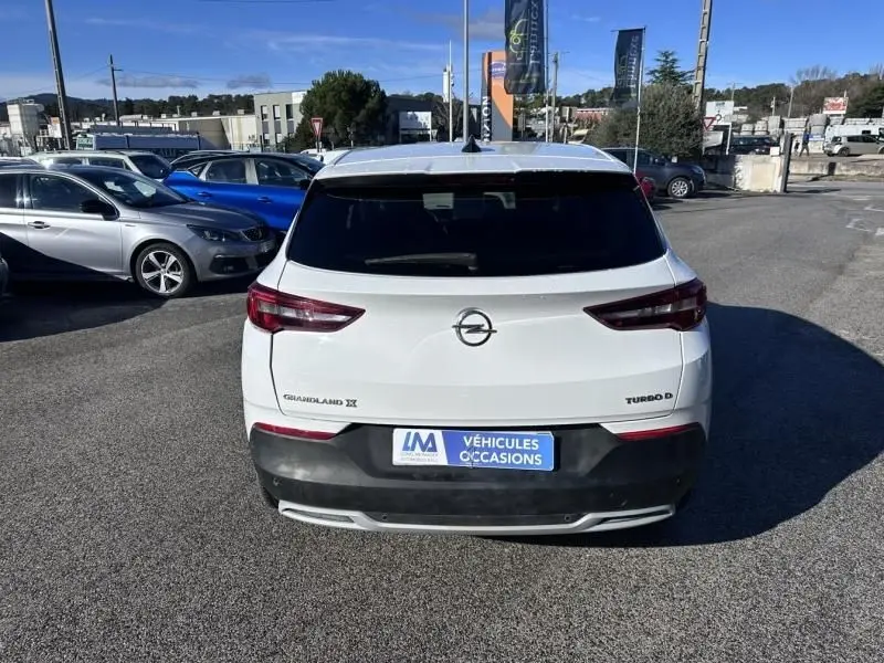 Vue arrière d'un Opel Grandland X blanc de 2018, avec logos "Grandland X" et "Turbo D" visibles sur le hayon.