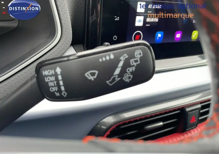 Gros plan sur la commande d’essuie-glace à gauche du volant dans l’habitacle du SEAT Arona bleu saphir 2025.