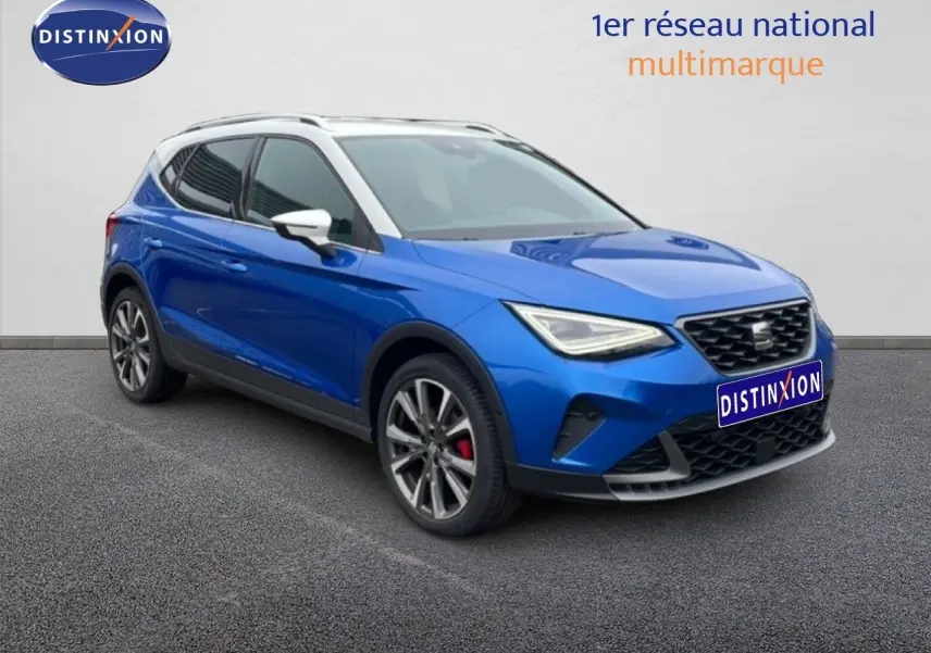 SEAT Arona 2025 bleu saphir métal avec toit blanc, vue 3/4 avant mettant en valeur les jantes alliage et les étriers rouges.
