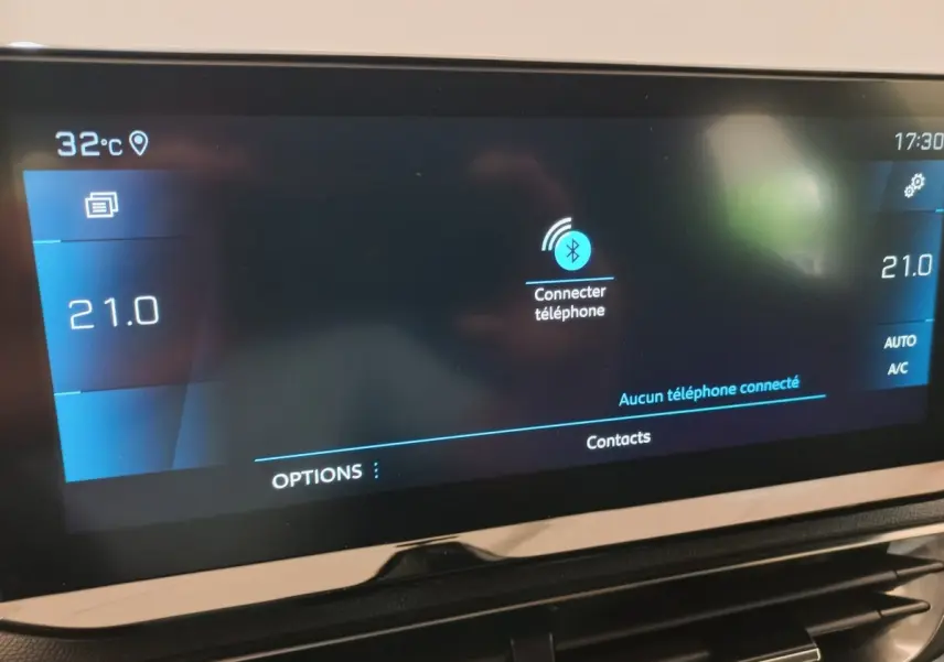 Écran tactile central du tableau de bord du Peugeot 3008 noir, affichant la connexion Bluetooth et la température à 21°C.