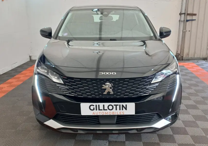 Vue avant d’un Peugeot 3008 noir 2022 avec calandre distinctive et feux LED en forme de griffes allumés.