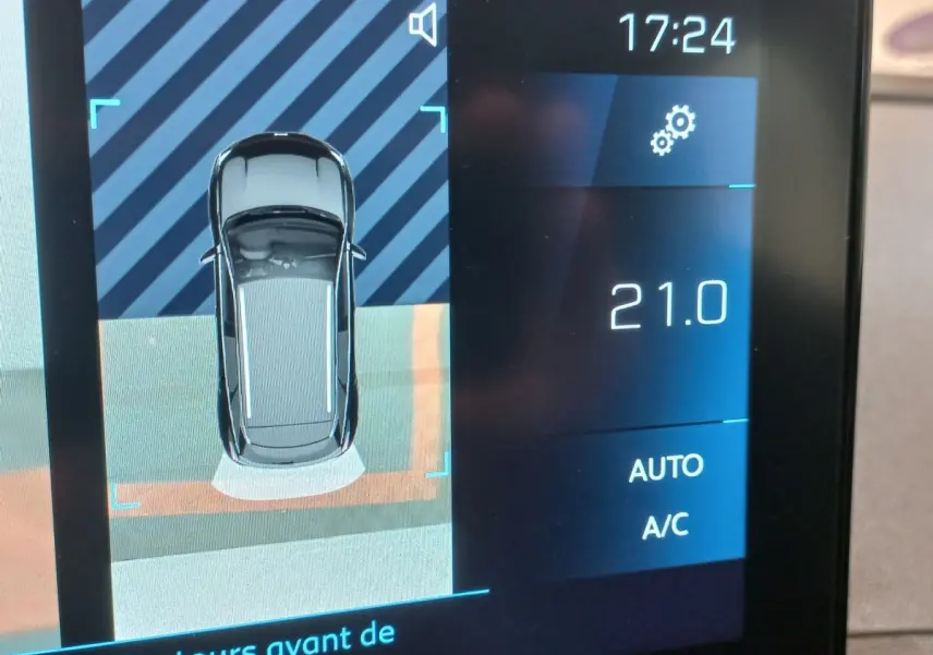 Affichage tactile intérieur montrant la vue aérienne du Peugeot 3008 noir en stationnement avec température à 21°C.