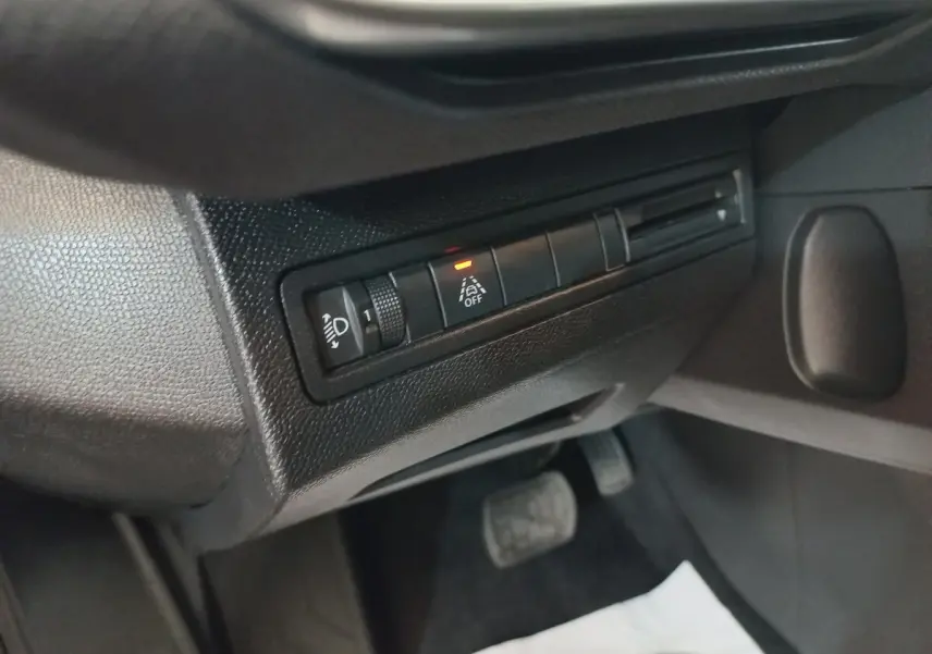 Détail intérieur côté gauche du tableau de bord noir du Peugeot 3008 2022 avec commandes d’éclairage et assistance à la conduite.