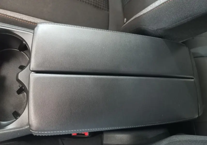 Accoudoir central noir en cuir vu de dessus dans l'habitacle du Peugeot 3008 PureTech 130 2022.