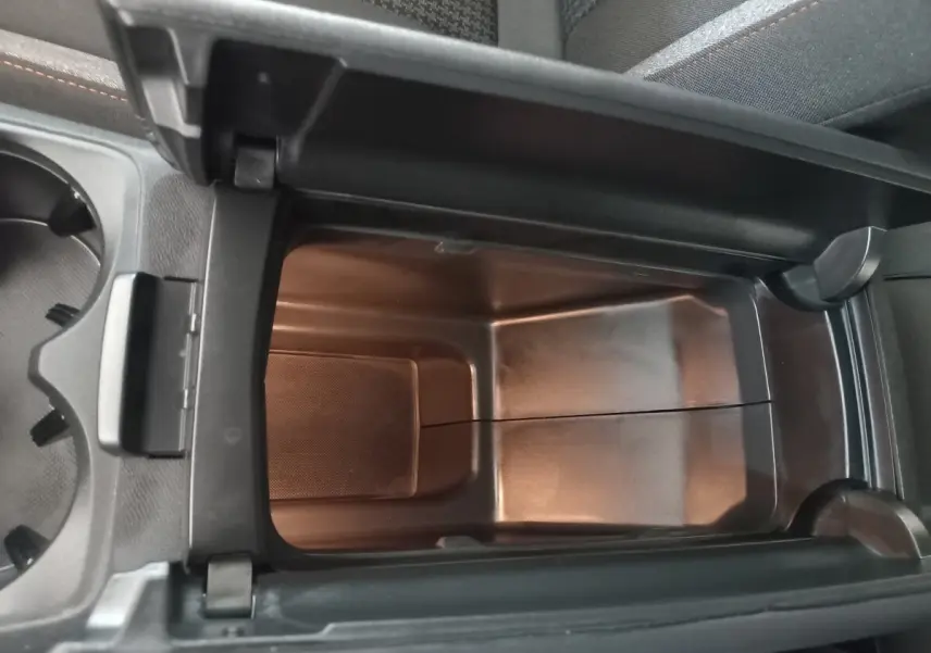 Vue plongeante sur le rangement réfrigéré noir dans l'accoudoir central du Peugeot 3008 2022 PureTech.
