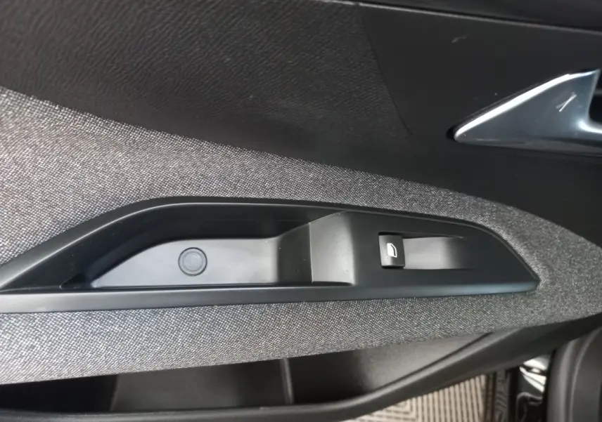 Détail de la commande de lève-vitre côté conducteur sur la porte intérieure du Peugeot 3008 noir, finition Active Pack.