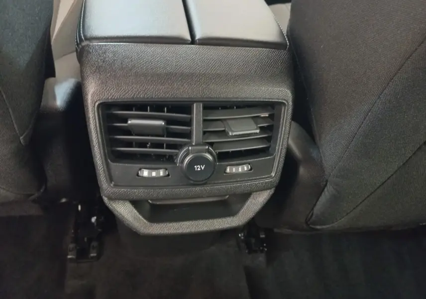Vue rapprochée de la console arrière noire avec sorties d'air et prise 12V du Peugeot 3008 2022.