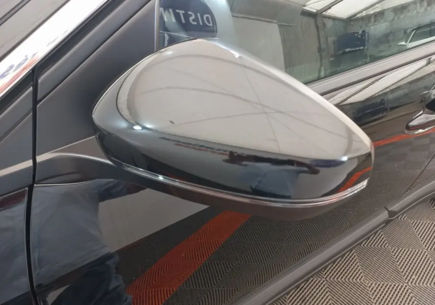 Rétroviseur côté gauche noir brillant du Peugeot 3008 2022, reflet net sur la carrosserie noire du véhicule.