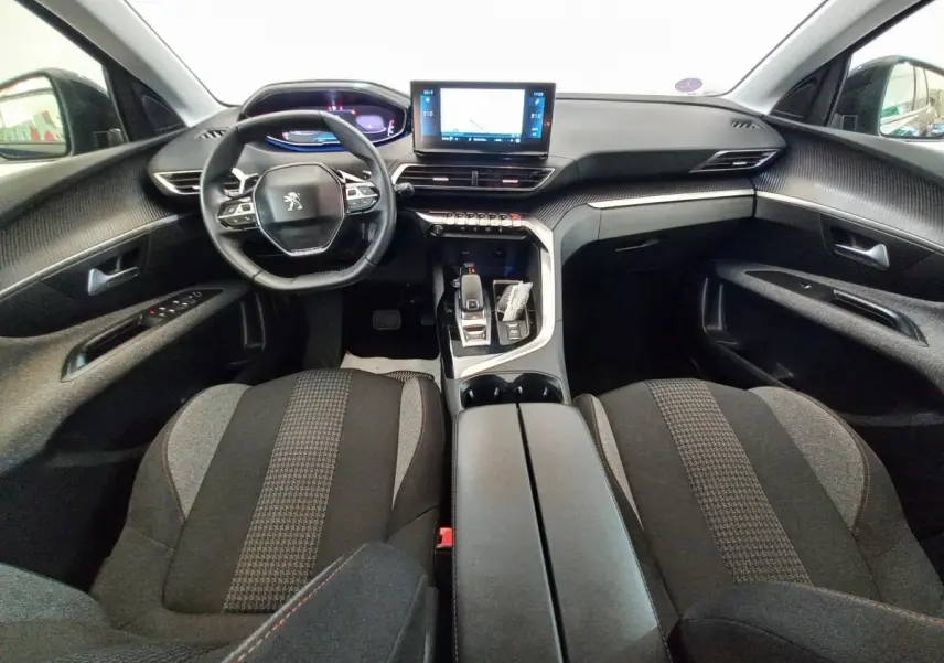 Intérieur Peugeot 3008 2022 vue avant, tableau de bord noir avec écran tactile central et volant compact multifonctions.