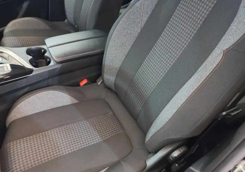 Gros plan sur le siège avant droit tissu gris et noir du Peugeot 3008 2022 avec accoudoir central et console noire.