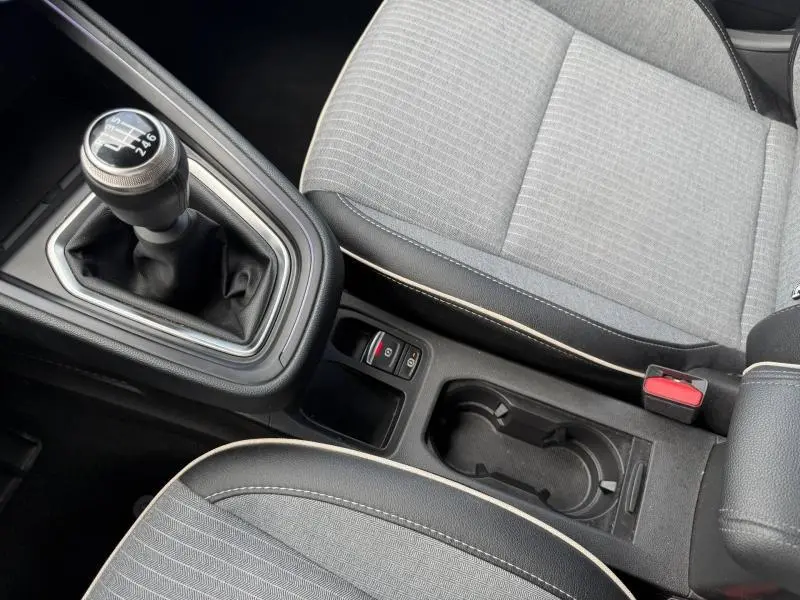 Vue rapprochée de la console centrale et levier de vitesse manuel de la Renault Clio gris schiste avec sièges tissu gris.