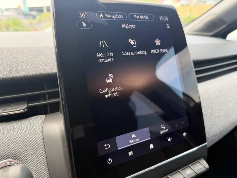 Gros plan sur l'écran tactile central du tableau de bord de la Renault Clio gris schiste, affichant les réglages d'aides à la conduite.