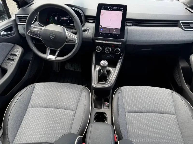 Vue intérieure avant de la Renault Clio 1.0 Eco-G 100ch Techno 2025, tableau de bord avec écran tactile vertical et sièges gris.