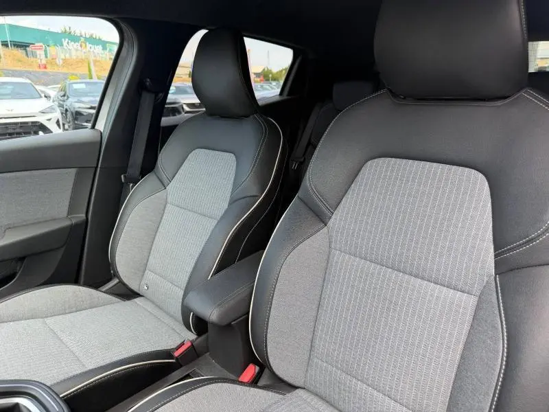 Vue rapprochée des sièges avant gris et noirs de la Renault Clio 1.0 Eco-G 100ch Techno 2025 avec accoudoir central.