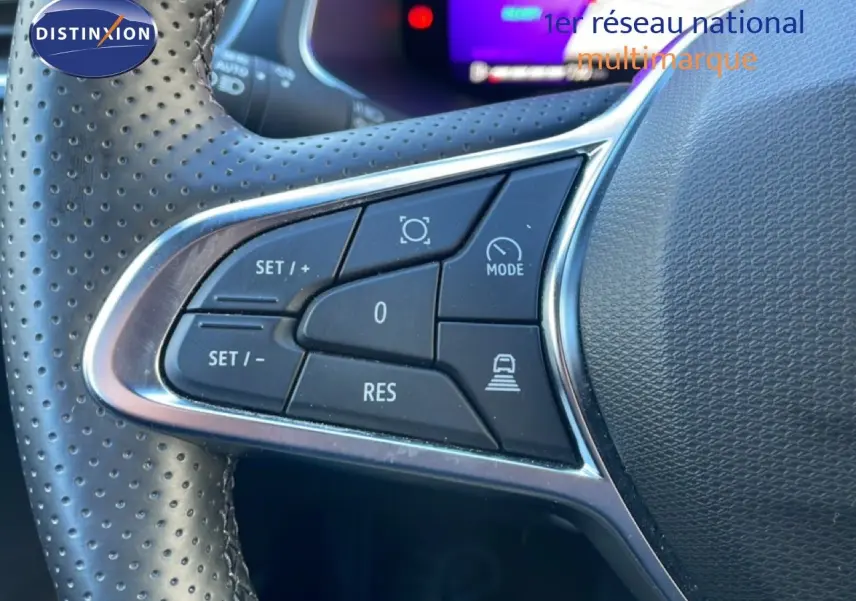 Gros plan sur les commandes au volant en cuir perforé noir du Renault Symbioz 2025, version hybride bleu iron metal.