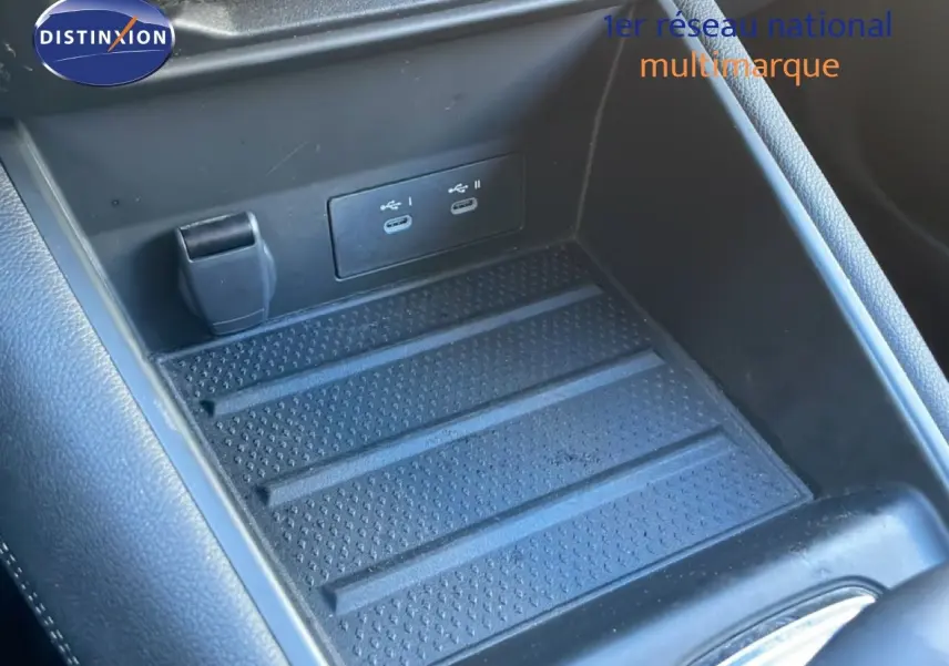 Gros plan sur la console centrale intérieure avec prise USB double et surface antidérapante noire du Renault Symbioz 2025.