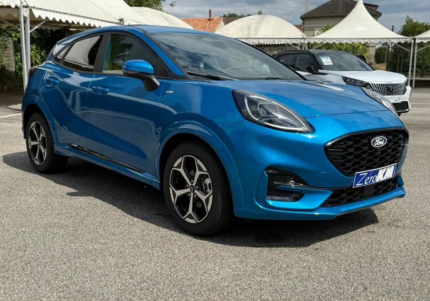 Ford Puma 2025 bleu Aqua Blue en 3/4 avant droit, avec calandre noire et jantes alliage distinctives ST Line.