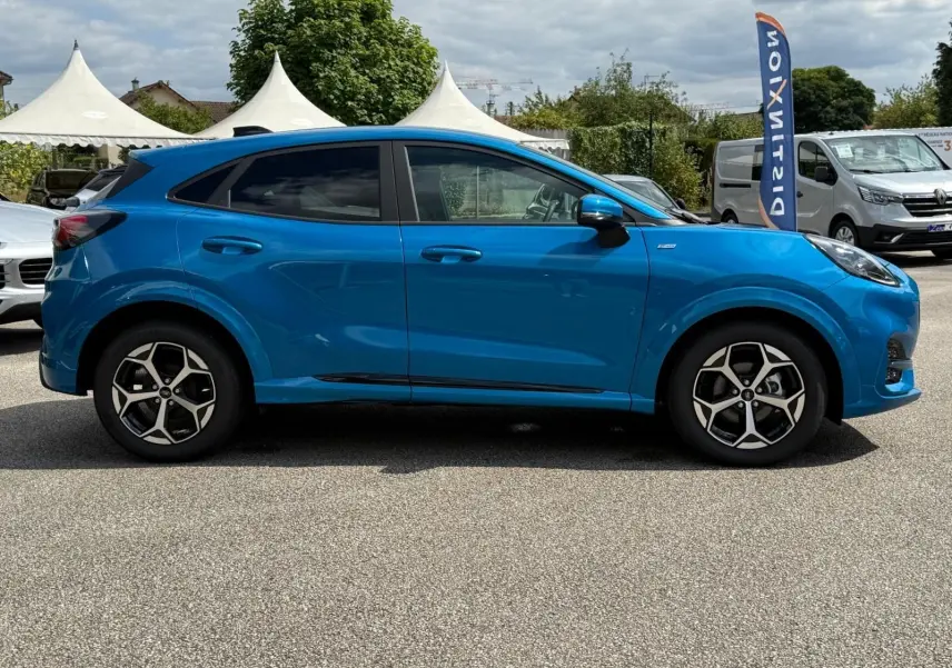 Profil côté gauche du Ford Puma 2025 bleu Aqua Blue avec jantes alliage et lignes sportives ST Line visibles.