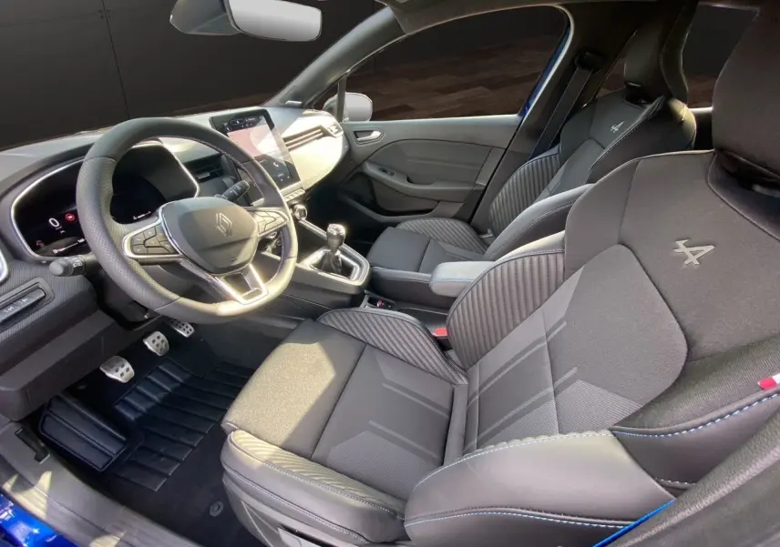 Intérieur noir de la Renault Clio V TCE 90 Esprit Alpine, vue côté conducteur avec sièges sport et volant multifonction.