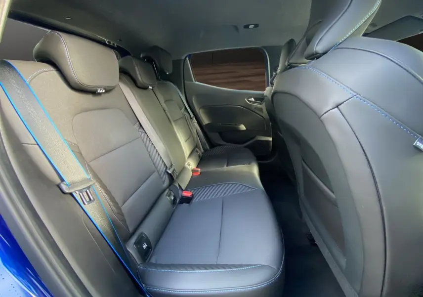 Vue intérieure arrière de la Renault Clio V TCE 90 Esprit Alpine bleu Iron, sièges noirs avec surpiqûres bleues.