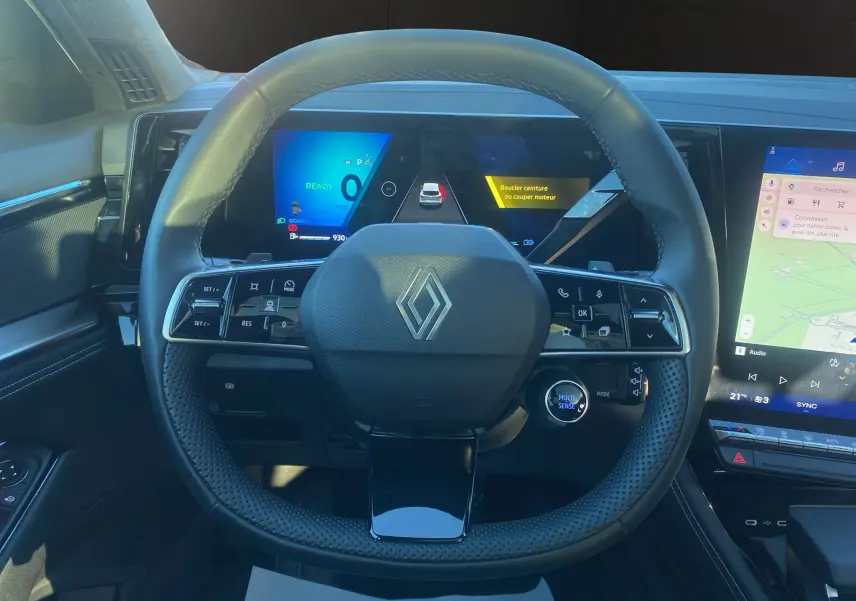 Vue intérieure centrée sur le volant multifonction et le tableau de bord numérique du Renault Austral Full Hybrid 2025.