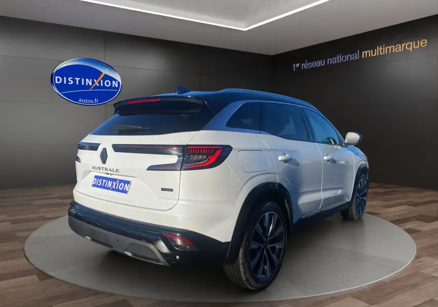 Vue 3/4 arrière droite du Renault Austral blanc nacré avec toit noir, jantes alu 19'' et caméra 360 visible.