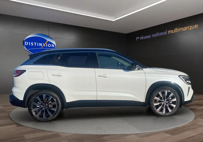 Vue de profil côté gauche d’un Renault Austral blanc nacré avec toit noir panoramique et jantes alu 19 pouces.