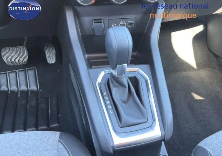 Gros plan sur la console centrale de la Renault Clio blanche 2025, montrant le levier de vitesse automatique et les pédales.