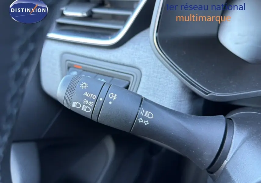 Gros plan sur la commande des phares et clignotants dans l’habitacle d’une Renault Clio blanche 2025.