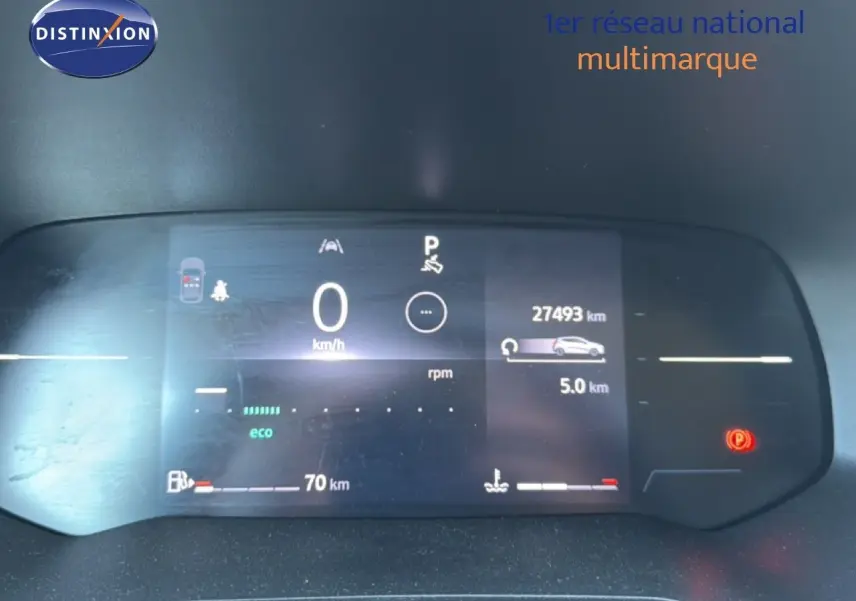 Tableau de bord numérique de Renault Clio blanc 2025 affichant 27 493 km et indicateurs de vitesse et carburant.