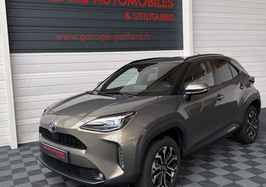 Toyota Yaris Cross gris clair vue 3/4 avant droit, avec jantes alliage et rétroviseurs argentés.