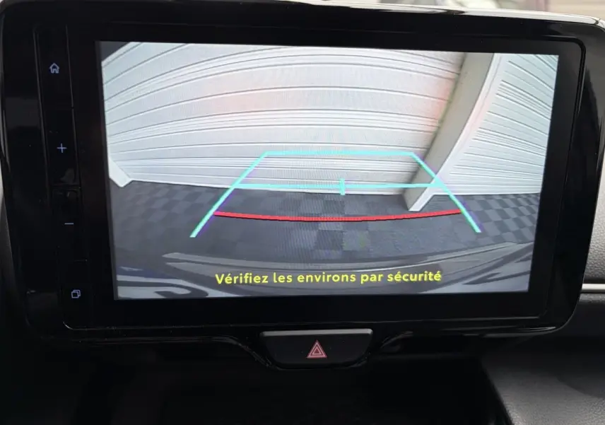 Écran tactile central montrant la caméra de recul avec guidage, à l'intérieur d'une Toyota Yaris Cross gris clair 2024.