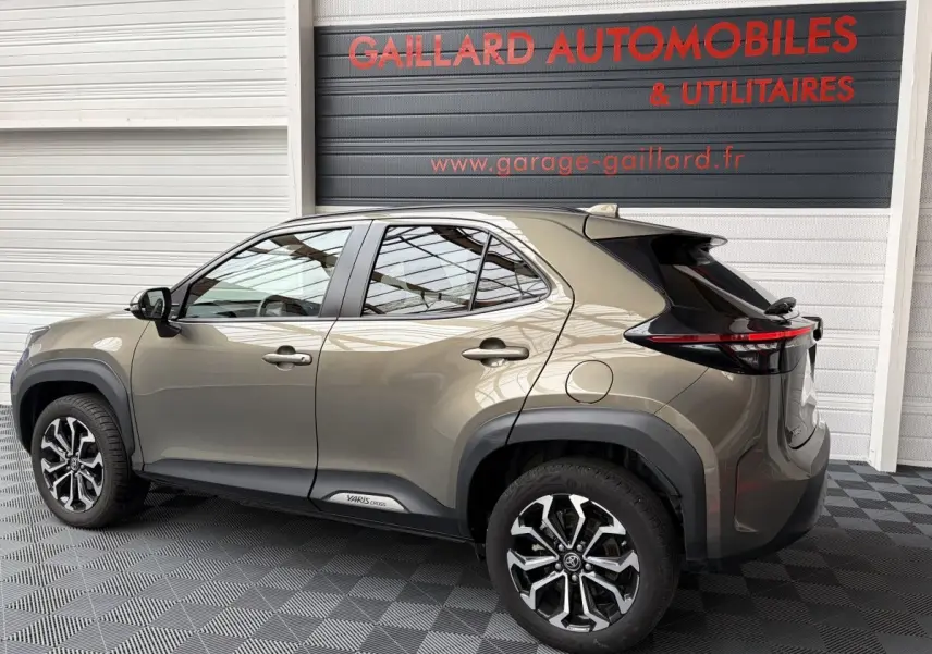 Vue latérale droite d'un Toyota Yaris Cross gris clair 2024 avec jantes alliage et détails noirs contrastants.