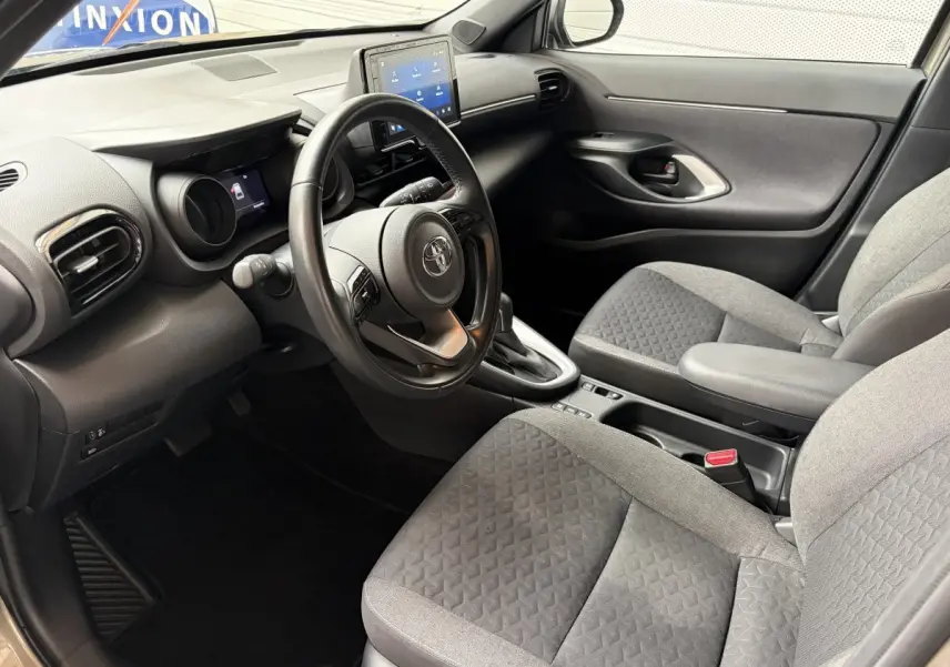Intérieur avant droit de la Toyota Yaris Cross 1.5 Hybrid 116h avec volant cuir multifonctions et écran tactile central.