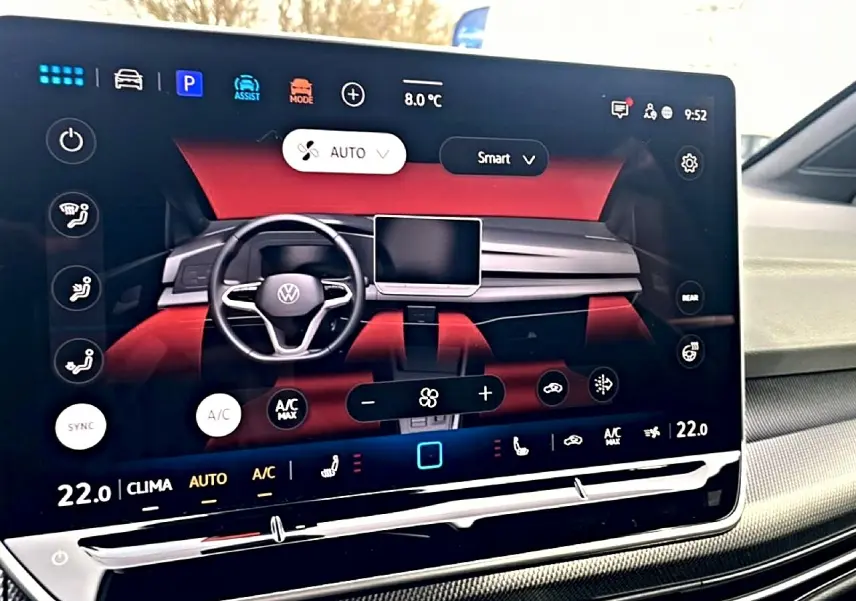 Écran tactile central affichant l'interface de climatisation de la Volkswagen Golf 2026 avec tableau de bord rouge et noir.