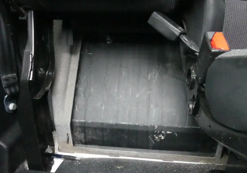 Détail du plancher bois noir et siège avant droit avec ceinture rouge dans le fourgon Peugeot Expert blanc 2019