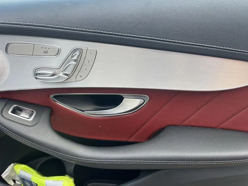Détail de la porte intérieure côté gauche du Mercedes GLC Coupé 220 d 2016 avec cuir rouge et commandes argentées