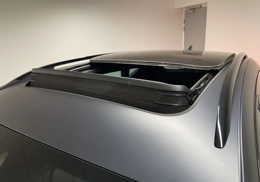 Toit ouvrant panoramique ouvert sur un CUPRA Formentor gris magnétique mat, vue rapprochée sur le toit et les barres de toit.