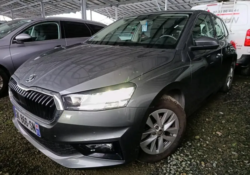 Vue 3/4 avant droite d'une Skoda Fabia gris graphite 2022 avec phares allumés et jantes alliage 15 pouces.