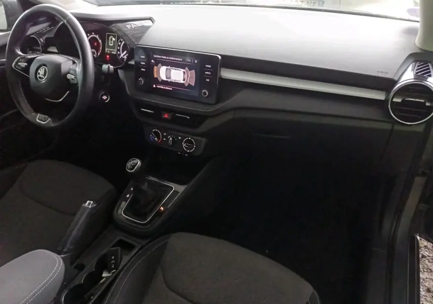 Vue intérieure côté conducteur de la Skoda Fabia 1.0 TSI 95 Ambition 2022 avec tableau de bord noir et écran tactile central.