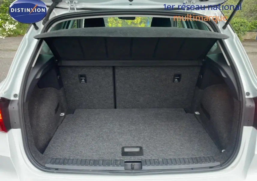 Coffre ouvert vu de l'arrière d'un SEAT Arona blanc alpin métal avec toit noir, montrant l'espace de chargement vide.